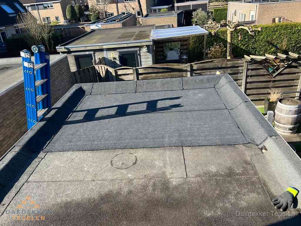 Dakdekker legt onderlaag op plat dak met houten constructie in Tegelen