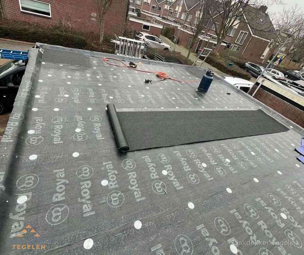 Dakdekker aan het werk met gasbrander op plat bitumen dak in Tegelen
