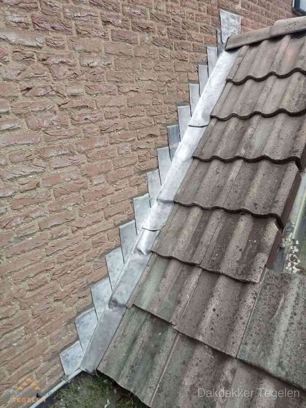 Loodslabben langs dakaansluiting bij bakstenen muur in Tegelen